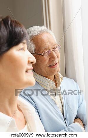 Stock Photo - Senior adult Japanese couple in the living room. Fotosearch