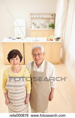 Stock Photograph - Senior adult Japanese couple in the kitchen. Fotosearch