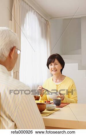 Stock Photograph - Senior adult Japanese couple in the kitchen. Fotosearch