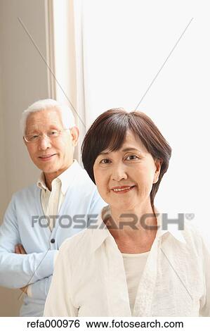 Stock Photograph - Senior adult Japanese couple in the living room. Fotosearch