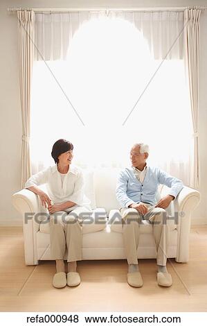 Stock Photo - Senior adult Japanese couple on the sofa. Fotosearch