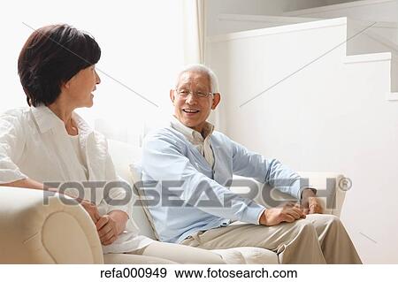 Stock Photo - Senior adult Japanese couple on the sofa. Fotosearch