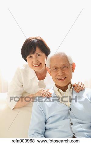 Stock Photo - Senior adult Japanese couple on the sofa. Fotosearch