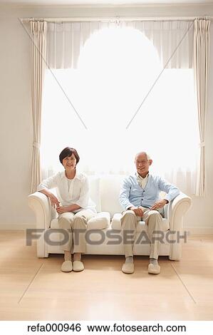 Stock Photograph - Senior adult Japanese couple on the sofa. Fotosearch