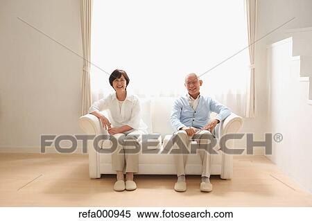 Stock Photography - Senior adult Japanese couple on the sofa. Fotosearch