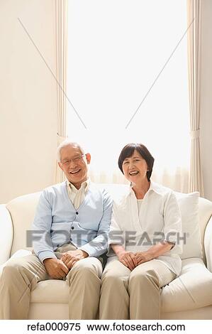 Stock Photography - Senior adult Japanese couple on the sofa. Fotosearch