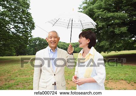 Senior adult Japanese couple with parasol in a park View Large Photo Image Picture - Senior adult Japanese couple with parasol in a park. Fotosearch