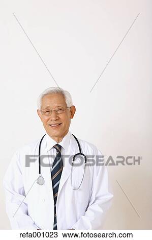 Senior adult Japanese doctor against white wall View Large Photo Image Stock Image - Senior adult Japanese doctor against white wall. Fotosearch