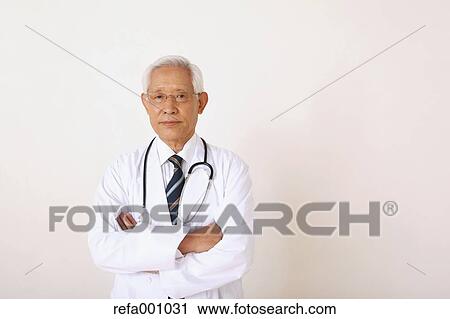 Senior adult Japanese doctor against white wall View Large Photo Image Stock Image - Senior adult Japanese doctor against white wall. Fotosearch