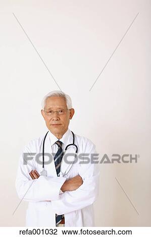 Senior adult Japanese doctor against white wall View Large Photo Image Stock Image - Senior adult Japanese doctor against white wall. Fotosearch