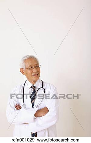 Senior adult Japanese doctor against white wall View Large Photo Image Stock Photo - Senior adult Japanese doctor against white wall. Fotosearch