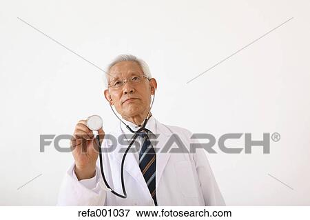 Stock Photo - Senior adult Japanese doctor against white wall. Fotosearch