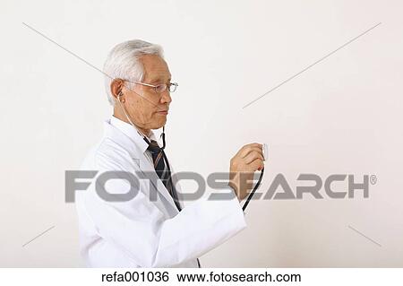 Stock Photograph - Senior adult Japanese doctor against white wall. Fotosearch