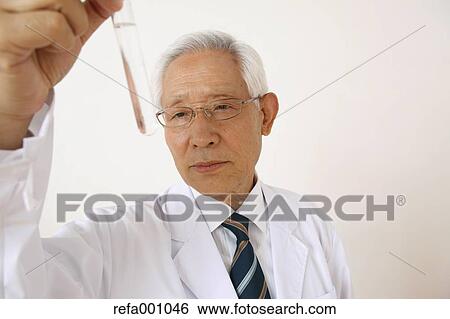 Stock Photograph - Senior adult Japanese doctor against white wall. Fotosearch
