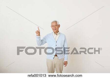 Stock Image - Senior adult Japanese man against white wall. Fotosearch