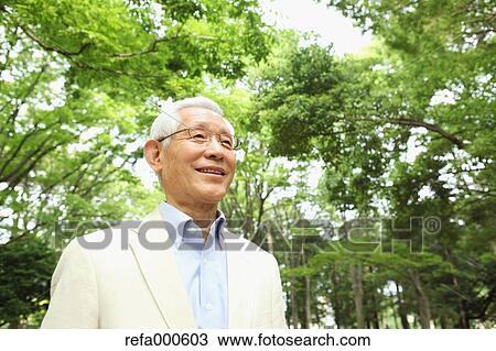 Stock Image - Senior adult Japanese man in a park. Fotosearch