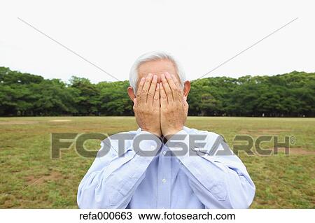 Stock Image - Senior adult Japanese man in a park. Fotosearch