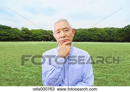 Stock Image - Senior adult Japanese man in a park. Fotosearch
