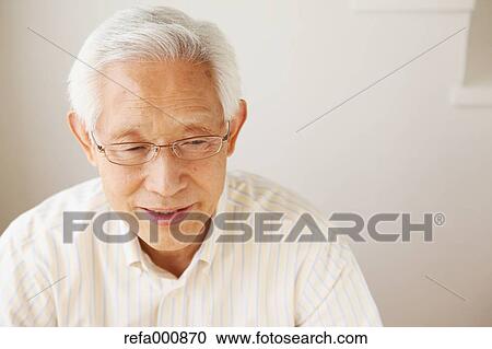 Stock Image - Senior adult Japanese man sitting. Fotosearch