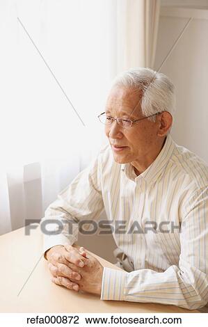 Stock Image - Senior adult Japanese man sitting. Fotosearch