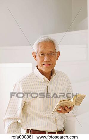 Stock Image - Senior adult Japanese man with book. Fotosearch