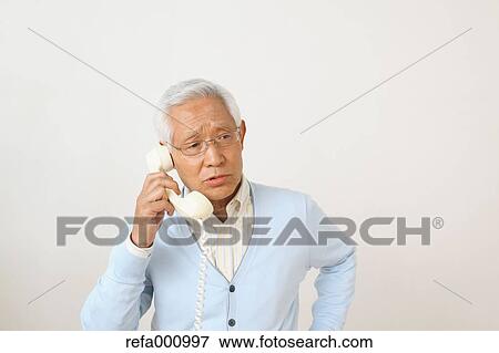 Senior adult Japanese man with phone against white wall View Large Photo Image Stock Photo - Senior adult Japanese man with phone against white wall. Fotosearch
