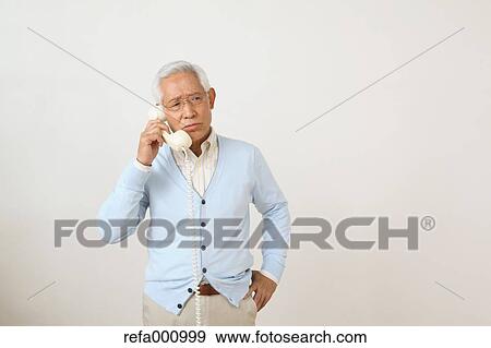 Senior adult Japanese man with phone against white wall View Large Photo Image Stock Photo - Senior adult Japanese man with phone against white wall. Fotosearch