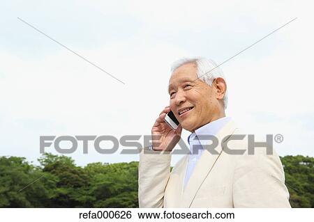Senior adult Japanese man with smartphone in a park View Large Photo Image Stock Photograph - Senior adult Japanese man with smartphone in a park. Fotosearch