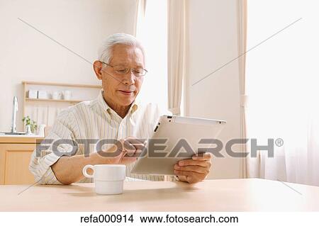 Senior adult Japanese man with tablet View Large Photo Image Picture - Senior adult Japanese man with tablet. Fotosearch