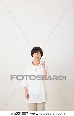 Stock Photo - Senior adult Japanese woman against white wall. Fotosearch