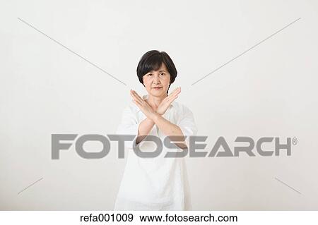 Stock Photo - Senior adult Japanese woman against white wall. Fotosearch