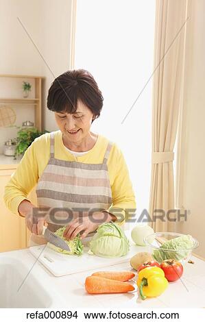 Picture - Senior adult Japanese woman cooking. Fotosearch