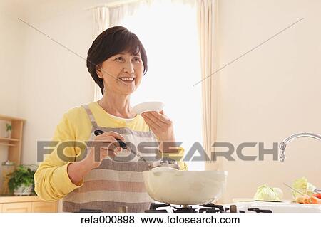 Senior adult Japanese woman cooking View Large Photo Image Stock Photo - Senior adult Japanese woman cooking. Fotosearch