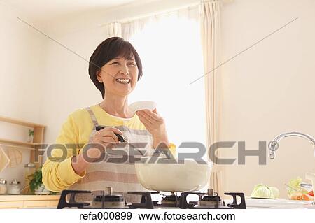 Senior adult Japanese woman cooking View Large Photo Image Stock Photo - Senior adult Japanese woman cooking. Fotosearch
