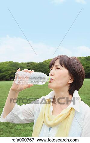 Senior adult Japanese woman drinking water in a park View Large Photo Image Stock Photo - Senior adult Japanese woman drinking water in a park. Fotosearch