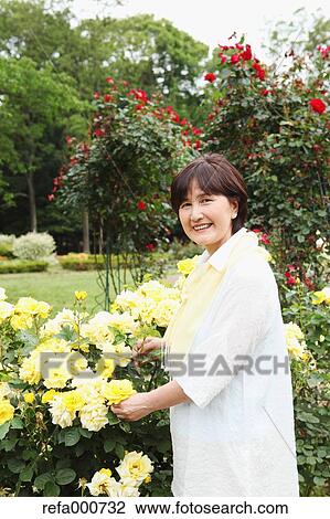 Stock Image - Senior adult Japanese woman in a park. Fotosearch