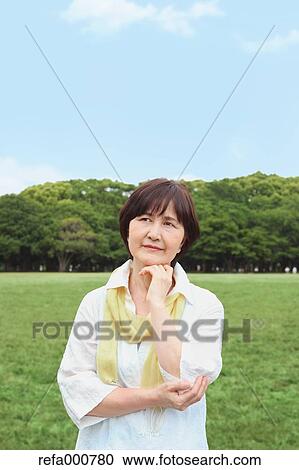 Stock Image - Senior adult Japanese woman in a park. Fotosearch