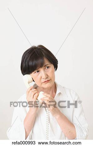 Senior adult Japanese woman with phone against white wall View Large Photo Image Stock Image - Senior adult Japanese woman with phone against white wall. Fotosearch
