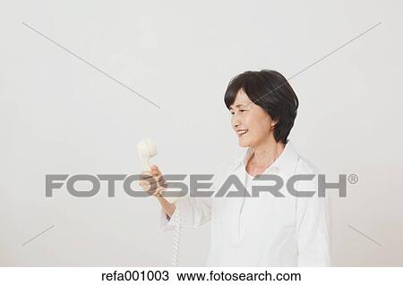 Senior adult Japanese woman with phone against white wall View Large Photo Image Stock Image - Senior adult Japanese woman with phone against white wall. Fotosearch