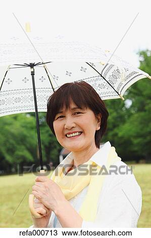 Senior adult Japanese woman with parasol in a park View Large Photo Image Stock Image - Senior adult Japanese woman with parasol in a park. Fotosearch