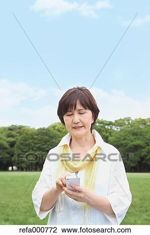 Senior adult Japanese woman with smartphone in a park View Large Photo Image Stock Image - Senior adult Japanese woman with smartphone in a park. Fotosearch