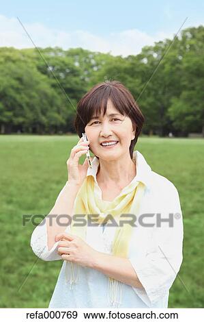 Senior adult Japanese woman with smartphone in a park View Large Photo Image Stock Photo - Senior adult Japanese woman with smartphone in a park. Fotosearch