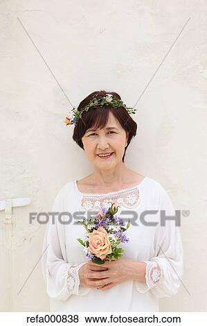 Senior adult Japanese woman with bouquet smiling View Large Photo Image Stock Photo - Senior adult Japanese woman with bouquet smiling. Fotosearch