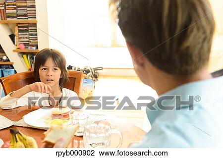 Young boy eating in the kitchen View Large Photo Image Stock Image - Young boy eating in the kitchen. Fotosearch