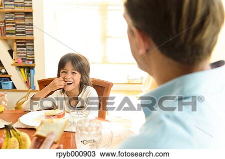 Young boy eating in the kitchen View Large Photo Image Stock Image - Young boy eating in the kitchen. Fotosearch