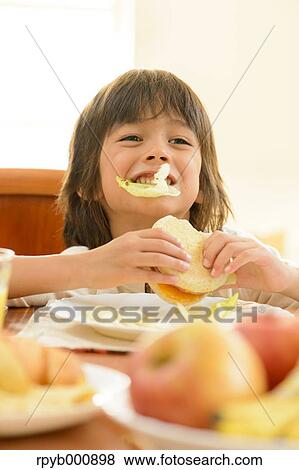 Young boy eating in the kitchen View Large Photo Image Stock Photo - Young boy eating in the kitchen. Fotosearch