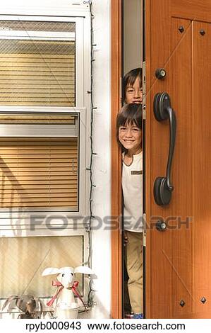 Stock Image - Young boys smiling at the entrance door. Fotosearch