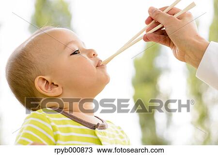 Young Japanese kid eating in a park View Large Photo Image Stock Image - Young Japanese kid eating in a park. Fotosearch