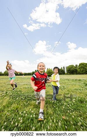 Stock Image - Young Japanese kids playing in a park. Fotosearch