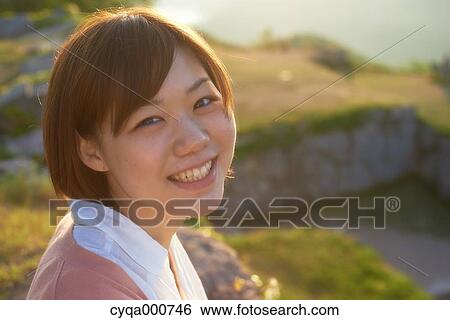 Young Japanese woman in the countryside looking at camera View Large Photo Image Stock Photograph - Young Japanese woman in the countryside looking at camera. Fotosearch